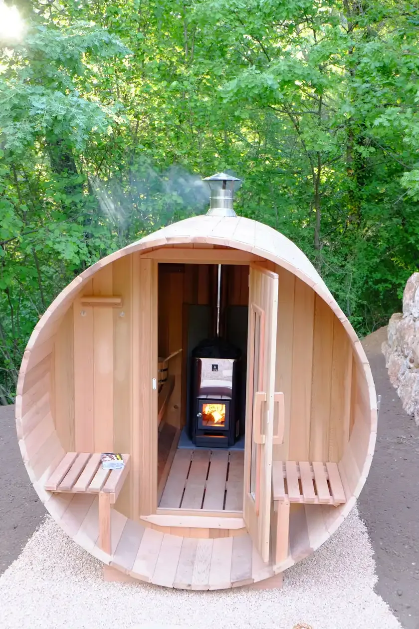De houtgestookte sauna met open deur en brandend vuur